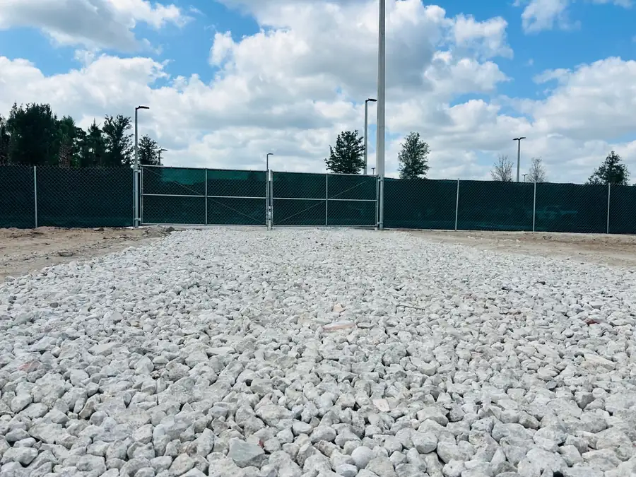Stabilized gravel construction entrance with screened chain-link fence
