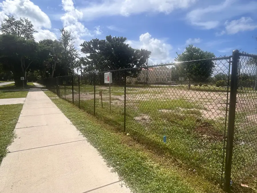 Black temporary chain-link fence purchased and installed along a sidewalk on a Florida job site