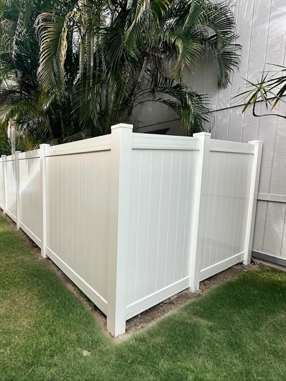 White vinyl privacy fence installed along a Martin County backyard